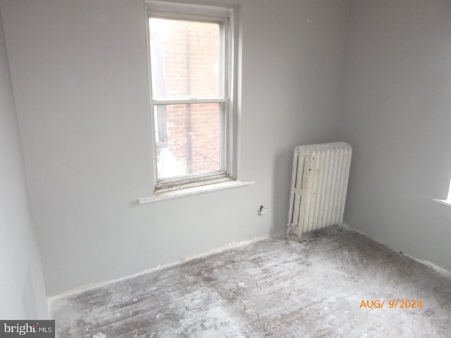 unfurnished room with radiator heating unit