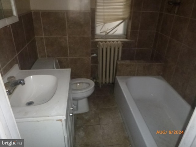 bathroom with vanity, a bathing tub, toilet, tile walls, and radiator heating unit