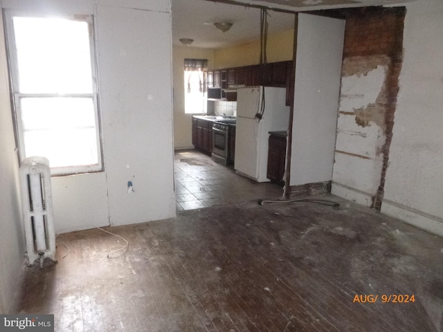 kitchen with hardwood / wood-style floors, radiator heating unit, stainless steel range, white fridge, and dark brown cabinetry