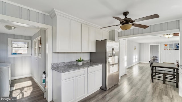 kitchen featuring stainless steel fridge with ice dispenser, ceiling fan, light stone countertops, light hardwood / wood-style floors, and white cabinetry