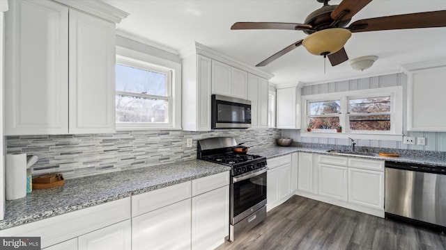 kitchen with white cabinets, light stone counters, sink, and stainless steel appliances