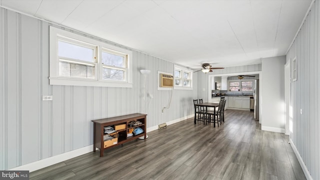 interior space with hardwood / wood-style floors, ceiling fan, and a wall unit AC