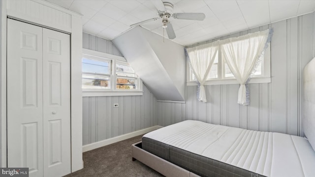 bedroom with multiple windows, ceiling fan, a closet, and dark carpet