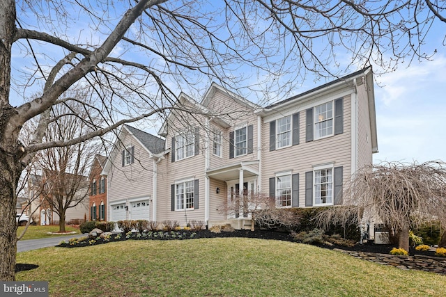 view of front facade with a garage, driveway, and a front lawn