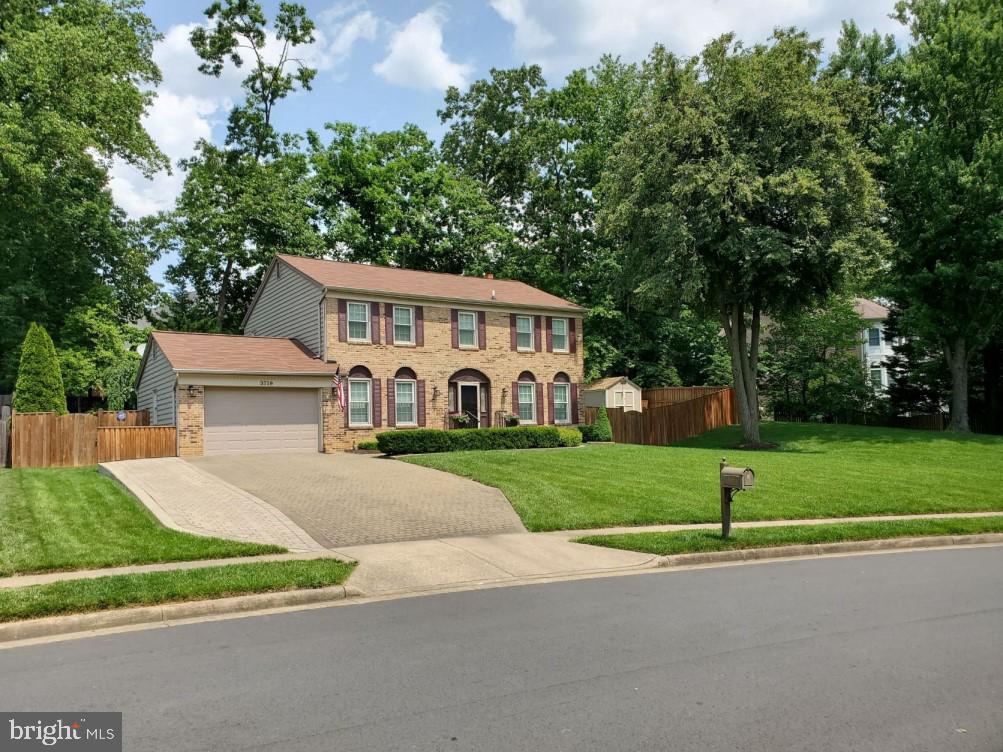 colonial house with a front yard and a garage