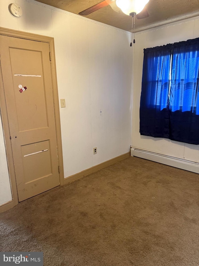 spare room with carpet, baseboard heating, and ceiling fan