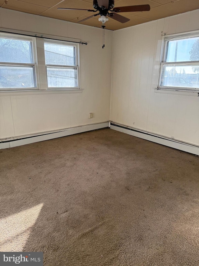 unfurnished room with carpet flooring, ceiling fan, and baseboard heating