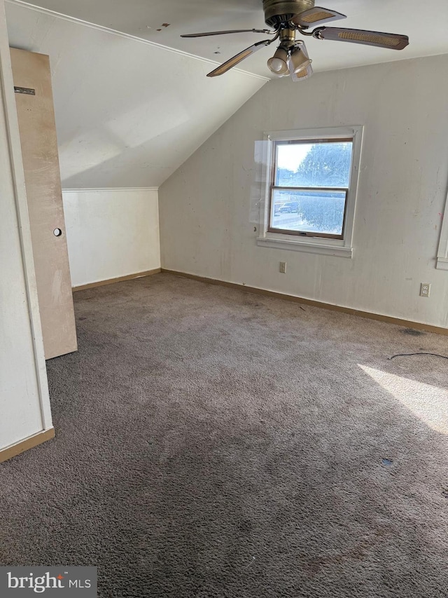 bonus room with ceiling fan, dark carpet, and vaulted ceiling