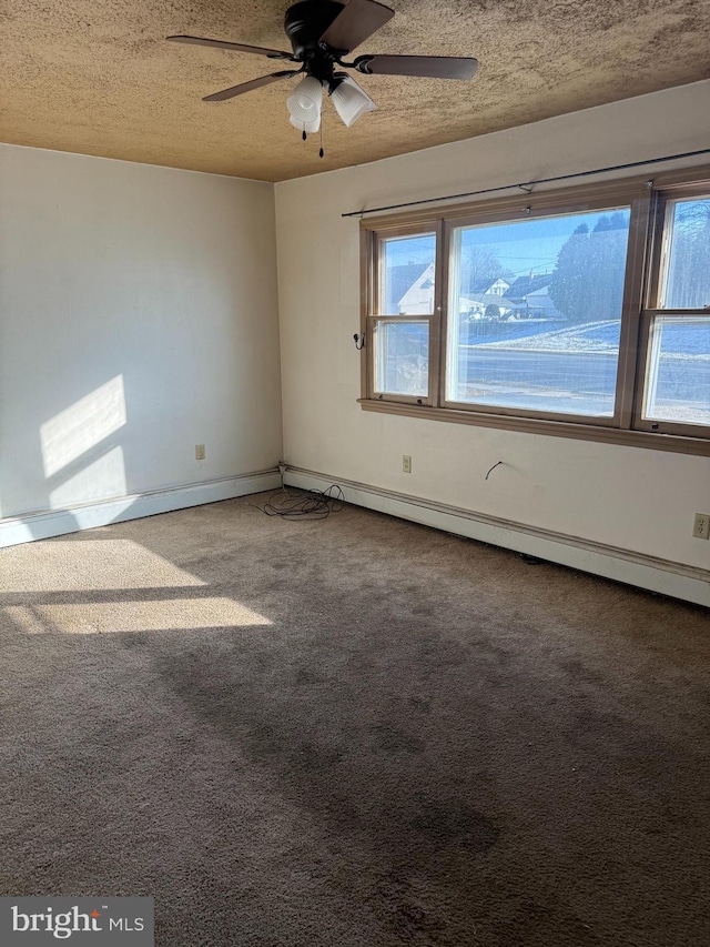 empty room with carpet flooring, a textured ceiling, baseboard heating, and ceiling fan