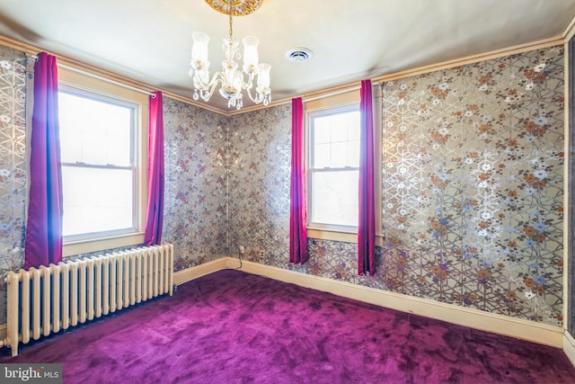 carpeted empty room featuring a chandelier, crown molding, radiator heating unit, and plenty of natural light