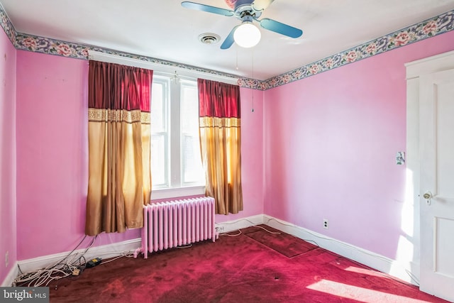 carpeted empty room with radiator, ceiling fan, and a wealth of natural light