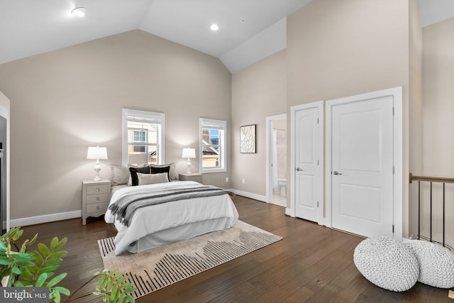 bedroom with high vaulted ceiling, connected bathroom, and dark hardwood / wood-style floors