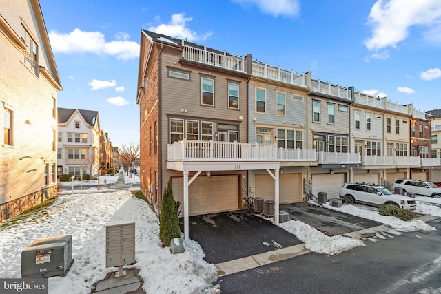 snow covered rear of property featuring central air condition unit