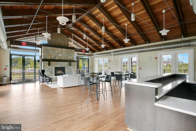 kitchen featuring wood ceiling, french doors, high vaulted ceiling, and a fireplace