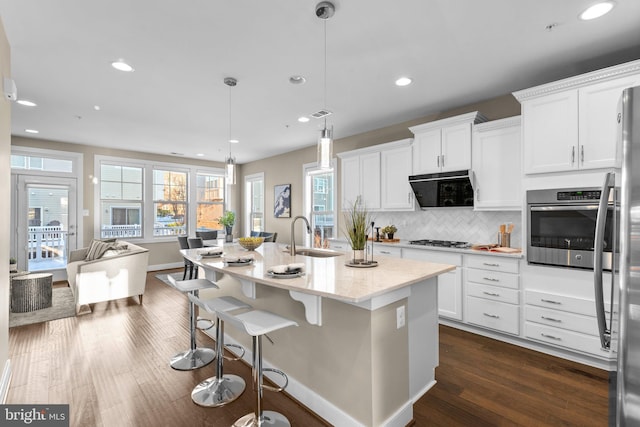 kitchen with decorative light fixtures, appliances with stainless steel finishes, and white cabinetry