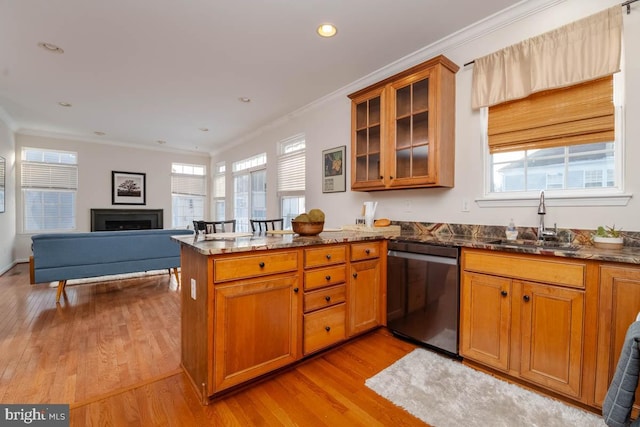 kitchen featuring kitchen peninsula, ornamental molding, dark stone counters, sink, and black dishwasher