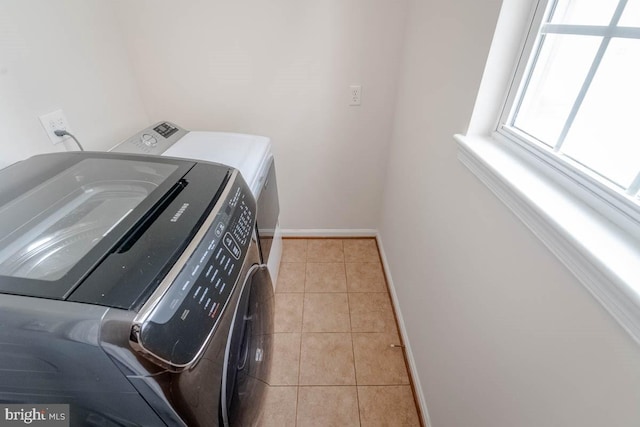 clothes washing area featuring separate washer and dryer and light tile patterned floors