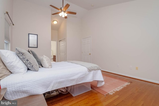 bedroom featuring hardwood / wood-style flooring, ceiling fan, and high vaulted ceiling