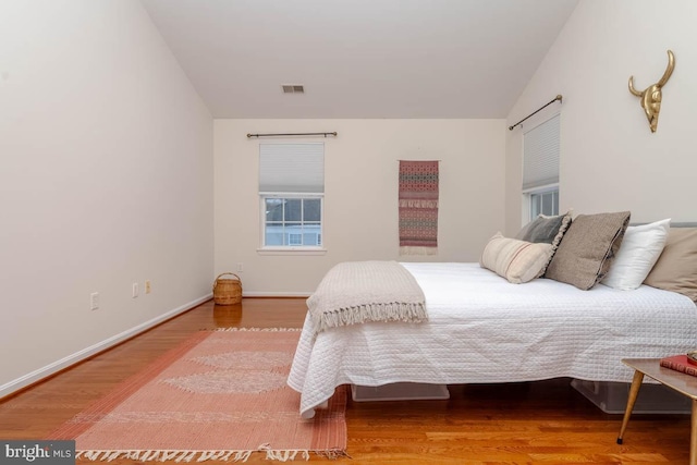 bedroom featuring hardwood / wood-style flooring and lofted ceiling