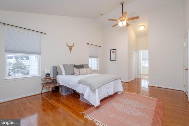 bedroom with ceiling fan, light hardwood / wood-style floors, and vaulted ceiling