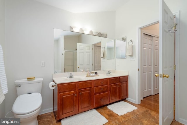 bathroom featuring vanity, toilet, and a shower with door