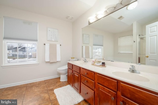 bathroom with tile patterned flooring, vanity, a healthy amount of sunlight, and toilet