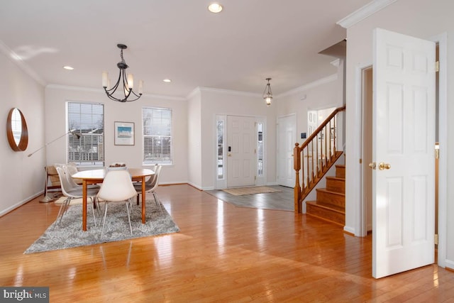 dining space featuring crown molding, light hardwood / wood-style flooring, and a notable chandelier