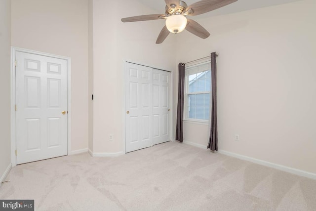 unfurnished bedroom with ceiling fan, light colored carpet, and a closet