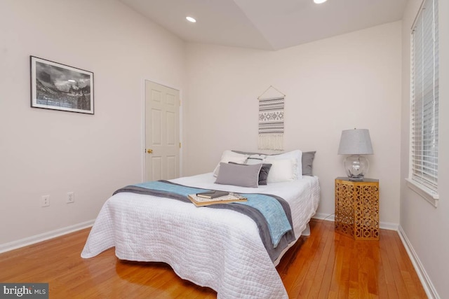 bedroom featuring wood-type flooring and vaulted ceiling