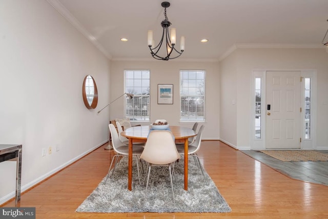 dining space featuring an inviting chandelier, light hardwood / wood-style flooring, and ornamental molding