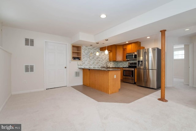 kitchen with kitchen peninsula, appliances with stainless steel finishes, decorative light fixtures, and light colored carpet