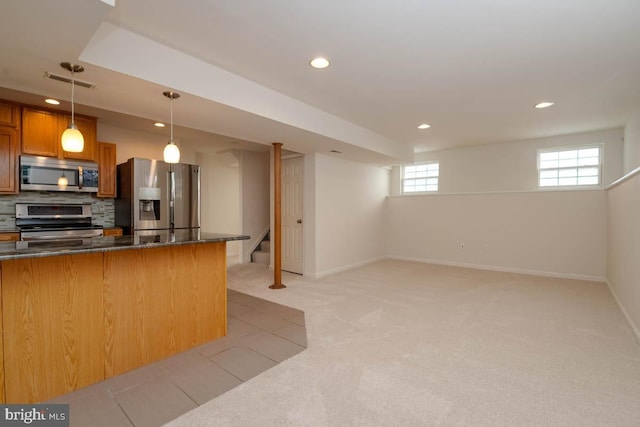 kitchen featuring tasteful backsplash, light colored carpet, stainless steel appliances, and decorative light fixtures