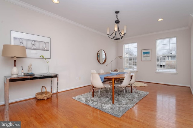 dining area featuring a chandelier, hardwood / wood-style floors, and crown molding