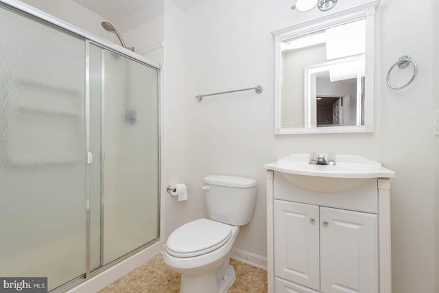 bathroom featuring vanity, toilet, and a shower with shower door