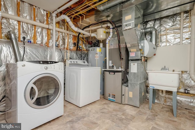 laundry room with washer and clothes dryer, gas water heater, and sink