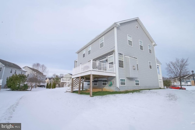 snow covered house with a deck