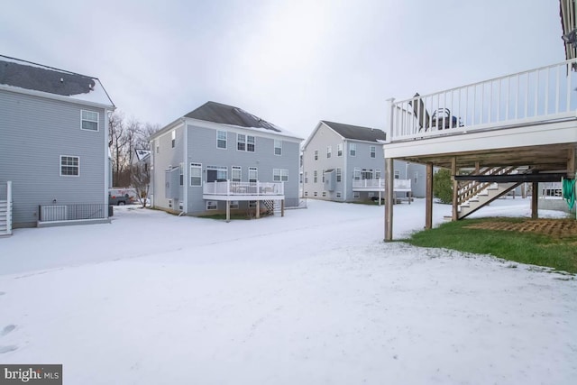 yard covered in snow with a deck