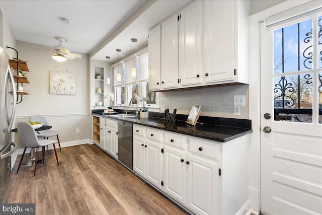 kitchen featuring sink, white cabinets, stainless steel dishwasher, decorative backsplash, and pendant lighting