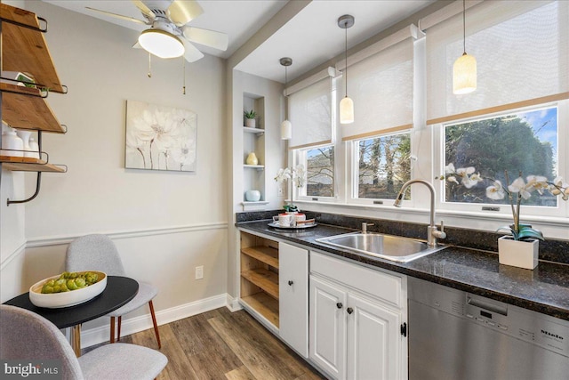 kitchen with stainless steel dishwasher, decorative light fixtures, built in shelves, white cabinets, and sink