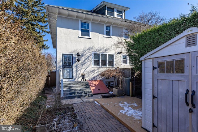 rear view of property with cooling unit and a storage unit