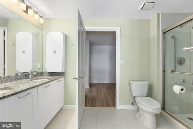 bathroom with tile patterned floors, walk in shower, toilet, and vanity