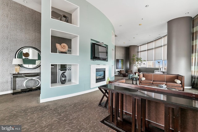 living room featuring a towering ceiling and dark colored carpet