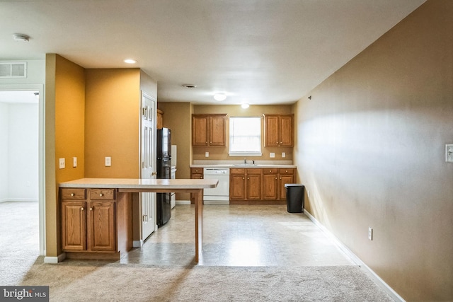 kitchen featuring dishwasher, light carpet, black refrigerator, and sink