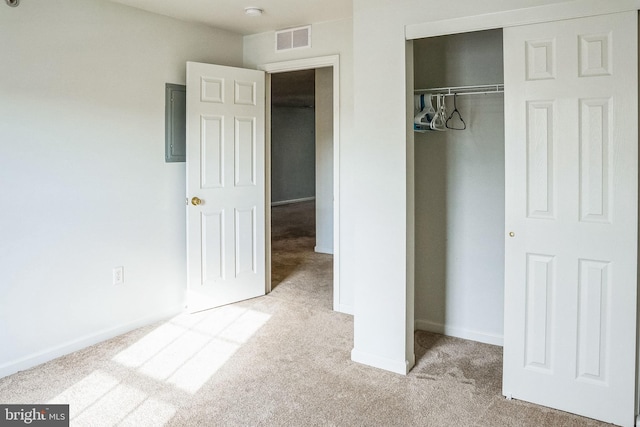 unfurnished bedroom with light colored carpet and a closet