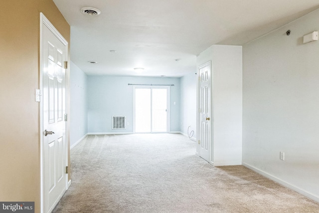 unfurnished room featuring light carpet