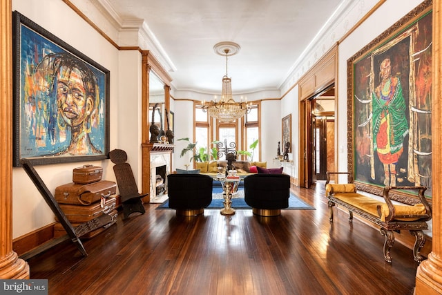 sitting room featuring a notable chandelier, crown molding, and hardwood / wood-style flooring