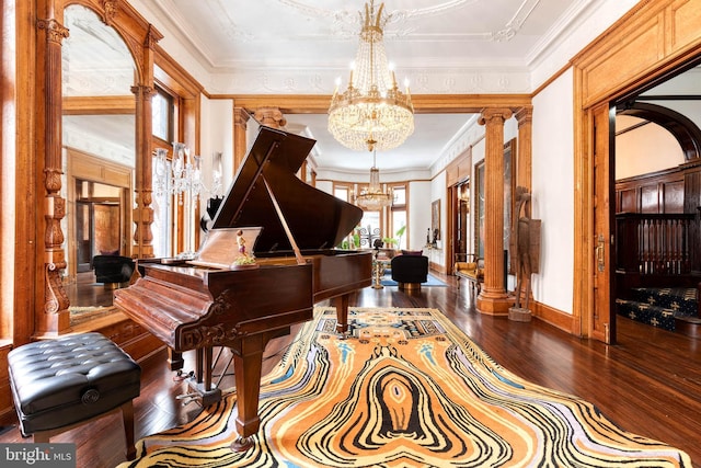 misc room with ornamental molding, dark hardwood / wood-style flooring, a chandelier, and decorative columns