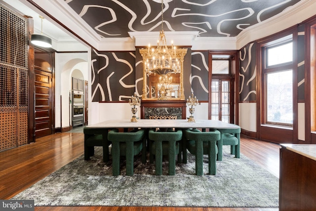 dining room featuring hardwood / wood-style flooring, ornamental molding, and a chandelier