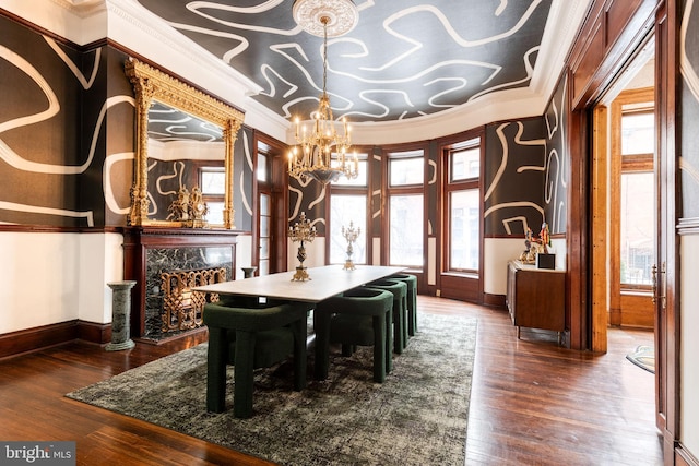 dining space with a healthy amount of sunlight, dark wood-type flooring, crown molding, and an inviting chandelier