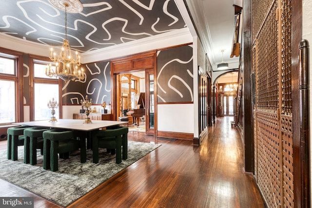 dining area featuring crown molding, dark hardwood / wood-style flooring, and an inviting chandelier